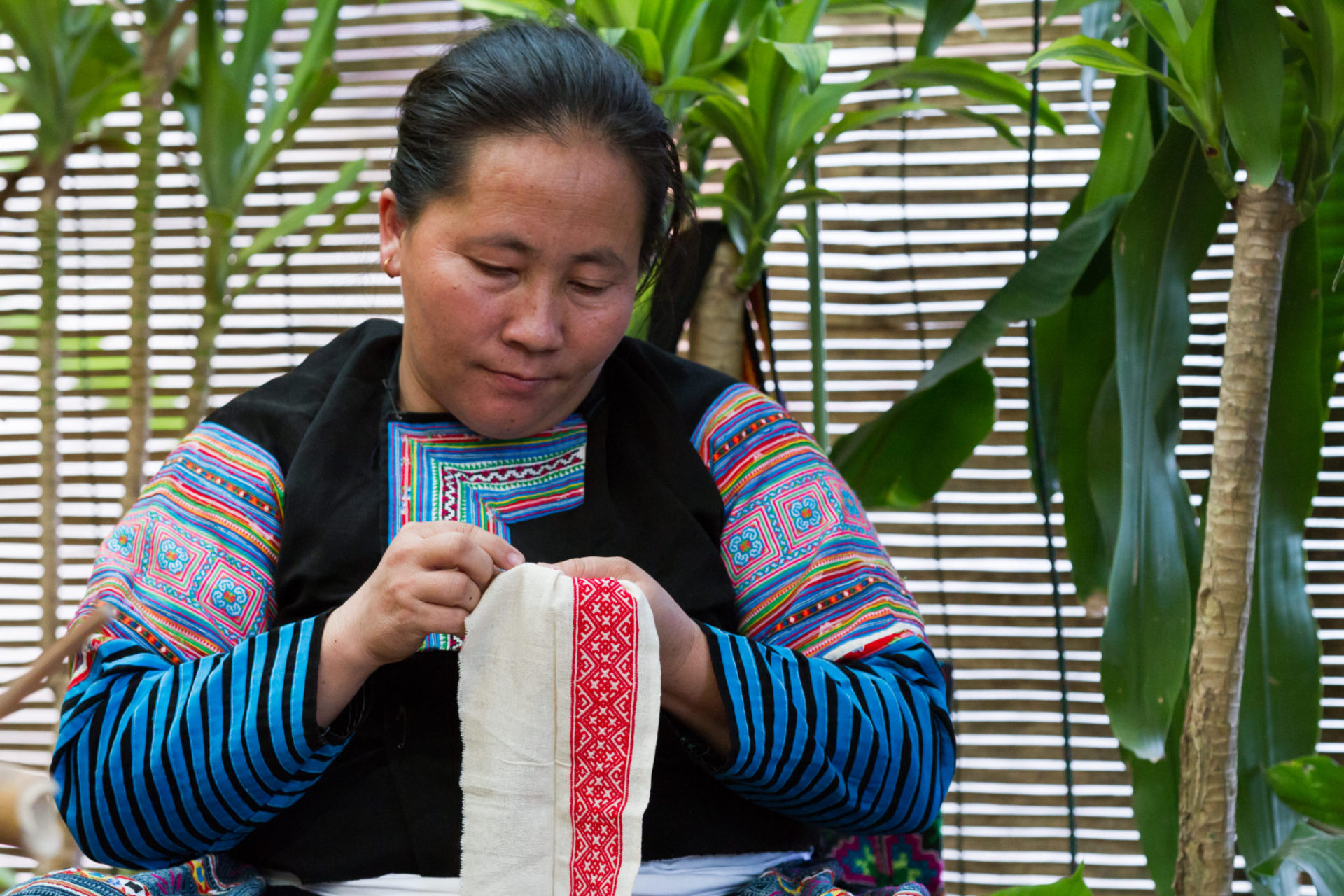 Mang Hmong artisan doing detailed embroidery