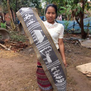 Krieng Nge artisan holding textile in village