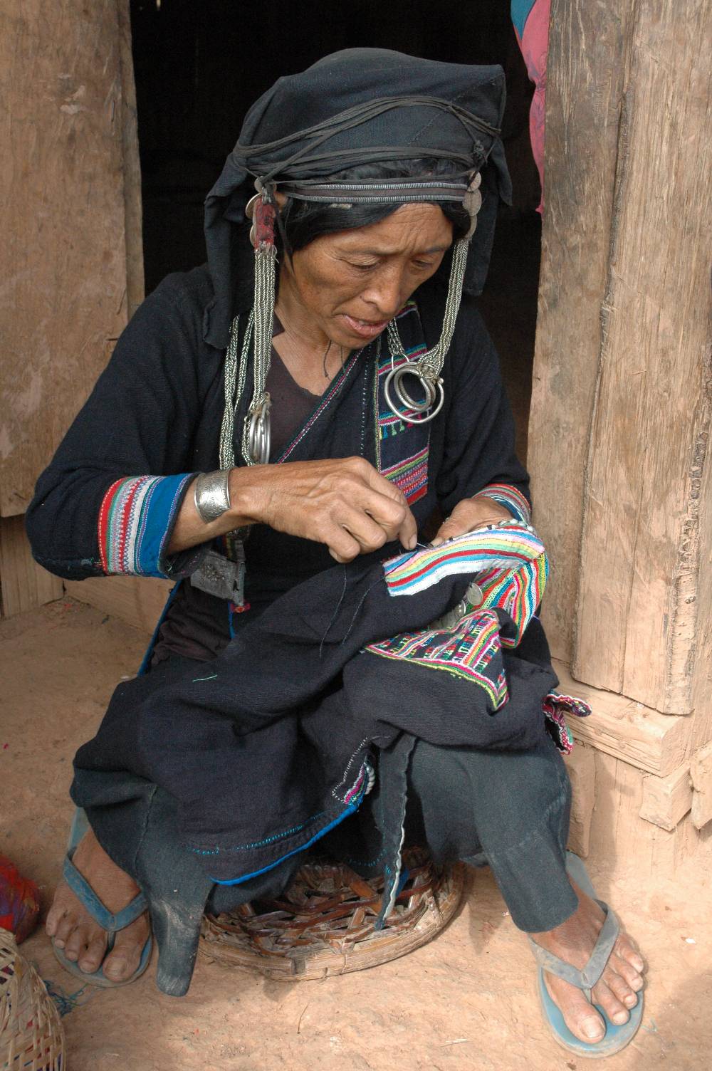 Akha woman stitching in Laos