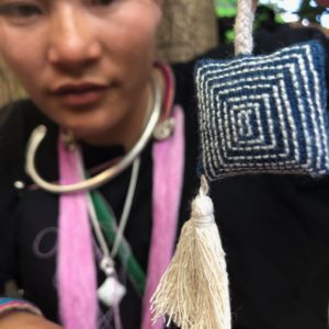 Lanten artisan holding embroidered ornament Laos